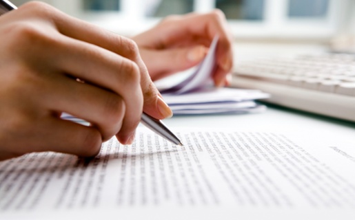 Close-up of a person writing on a piece of paper.