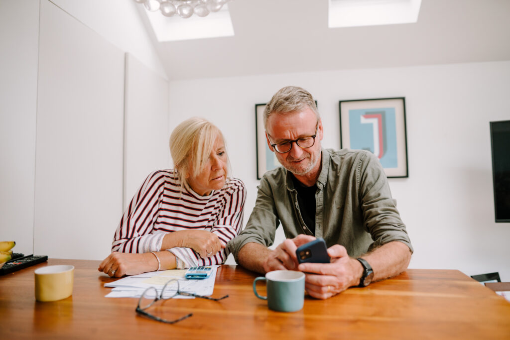 Two older people looking at a phone